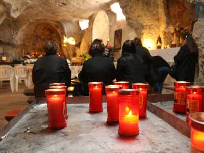 Nel frattempo la chiesa si � riempita di anziane rigorosamente vestite di nero che vanno a riempire il piccolo ambiente illuminato da ceri rossi